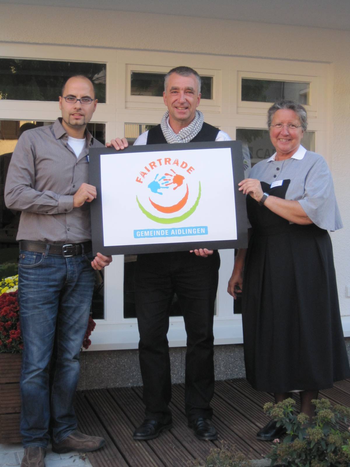  Bürgermeister Fauth überreicht dem Credo-Team den Aidlinger Fairtrade-Smiley 